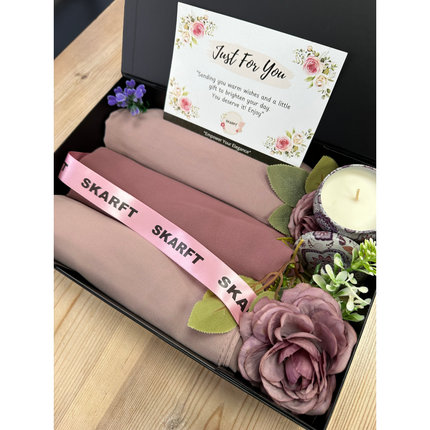 3 Hijabs in a black box on a table with scented candle and flowers
